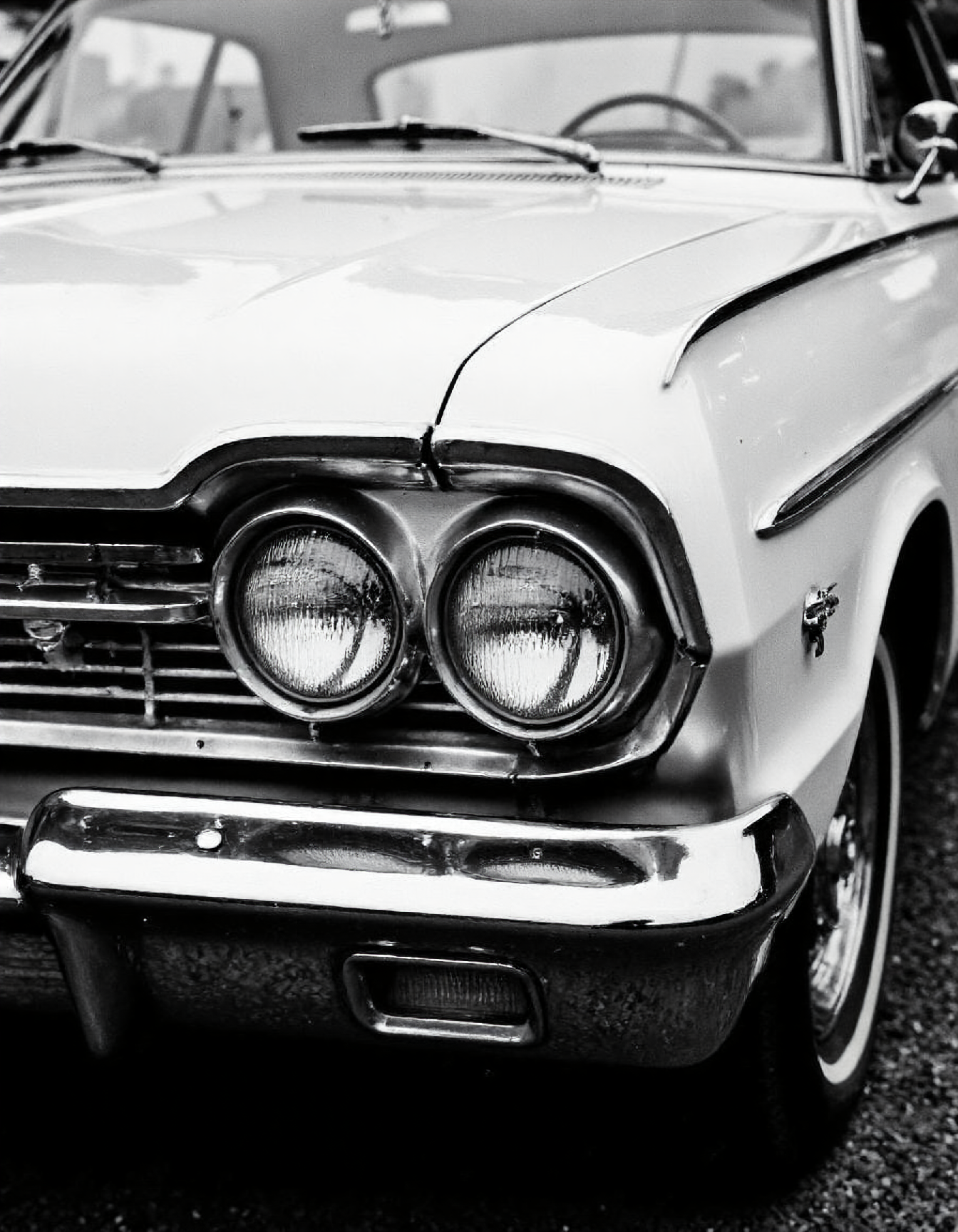 a black and white close-up photo of a 60s car