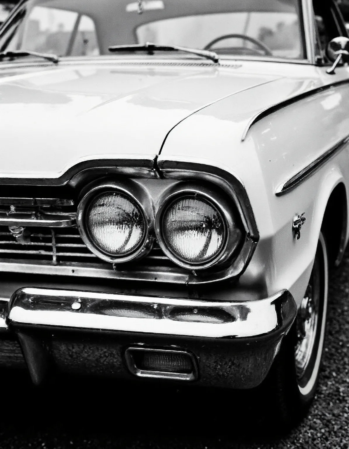 a black and white close-up photo of a 60s car