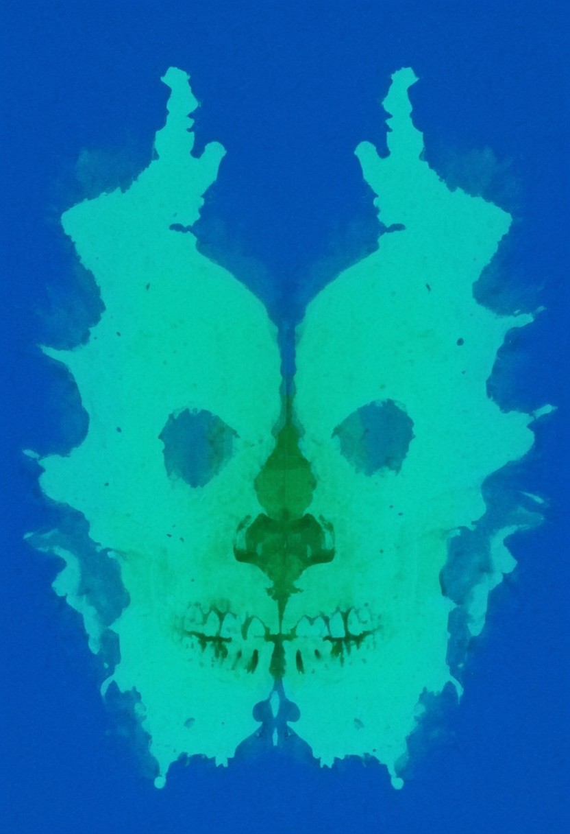 A rorschach-test resembling two symmetrical skulls, dark Blue/green translucent ink splashes