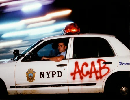 8n8log, police car ford crown victoria driving on high speed through a city at night. NYPD on the door and there is big red messy graffiti on the door "ACAB". The background is a blur of colorful, streaked lights from streetlights and other vehicles, creating a dynamic, energetic atmosphere. amateur quality, candid style, high contrast, grainy texture, low lighting conditions, dramatic contrast. policemen sitting on driver seat. details are smeared due to high speed