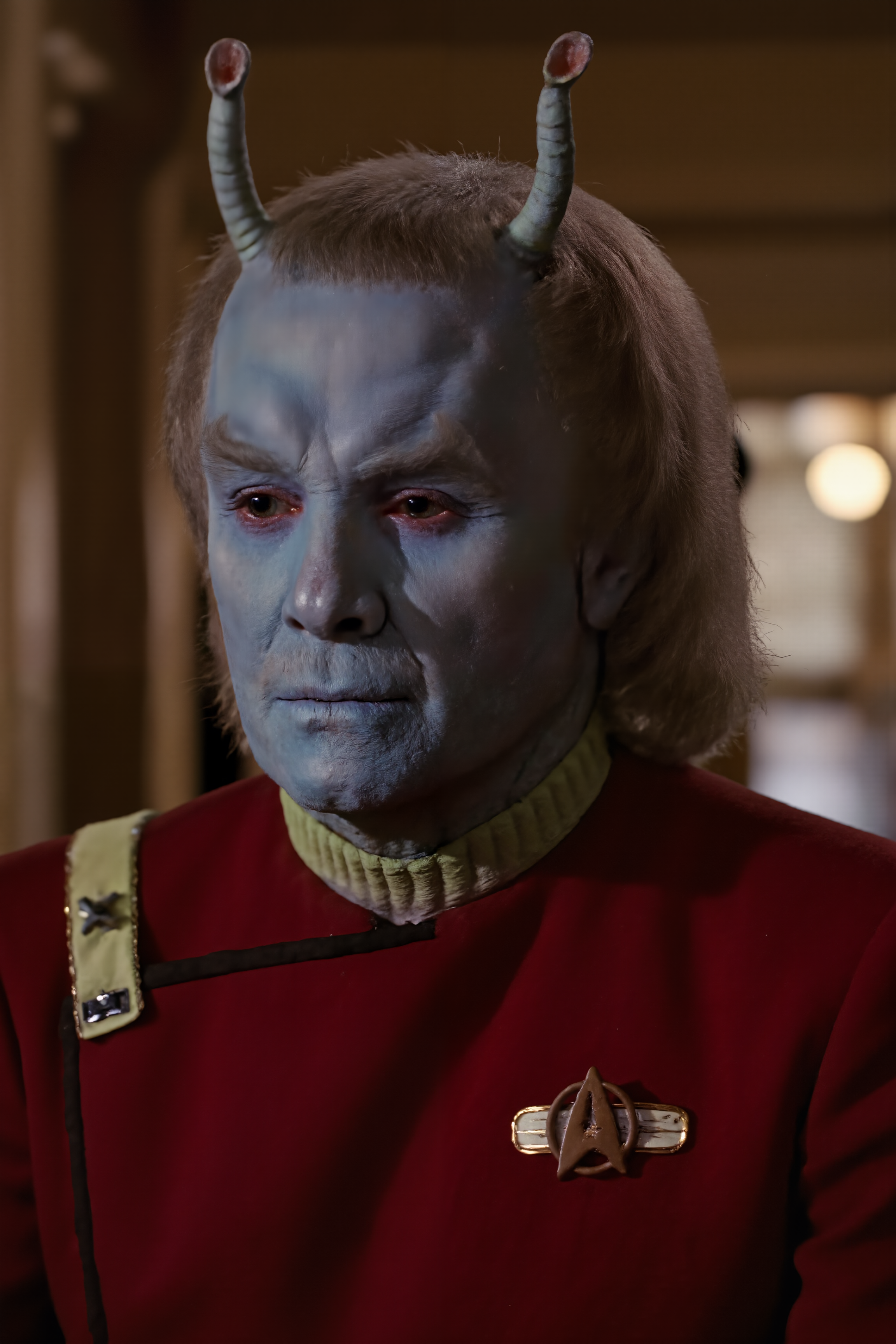 An andorian male man with blue skin and Antennae and with long hair and moustache stands in the ancient temple wearing red TWOK uniform, dark mustard yellow collar (photography, high-resolution, dynamic, energetic,hyper-realistic, dramatic lighting, shallow depth of field.), detailmaximizer, MythP0rt<lora:aidmaMJ6.1-FLUX-V0.1:0.6><lora:Movie_Portrait><lora:Flux DetailerV2><lora:TWOK_FLUX:1.1><lora:andorian_FLUX:1.1>