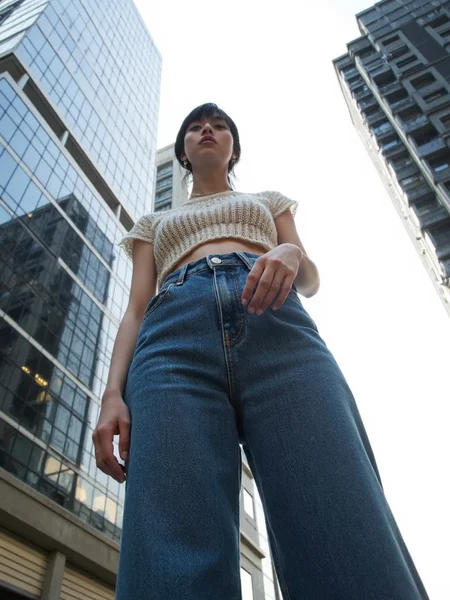 There are wonderful studio lights and various reflections,
18yo beautiful cute girl with blushing and female orgasm.skin naturally showing the texture of blood vessels and detailed pale skin,
--,
<lora:Nakajo_Ayami_f1:1>,she is Nakajo Ayami,
(Knit_cropped_top:1.4),(High-waisted_flared_jeans:1.3),(Platform_sandals:1.2), A bold fashion shot of a model standing tall in front of massive skyscrapers. The low-angle perspective makes her appear powerful and statuesque, her expression strong and determined. The background features towering city buildings with sharp lines contrasting against the bright sky. Street fashion editorial, wide-angle lens, f/2.0, natural light, hd quality,, #æ©å¤©æ¥¼ä½è§åº¦