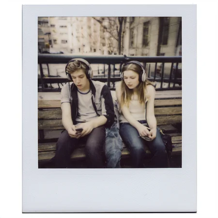 polaroid of Two teenagers, sharing headphones, lost in a shared melody on a city bench.  <lora:Polaroid_XL:1>
