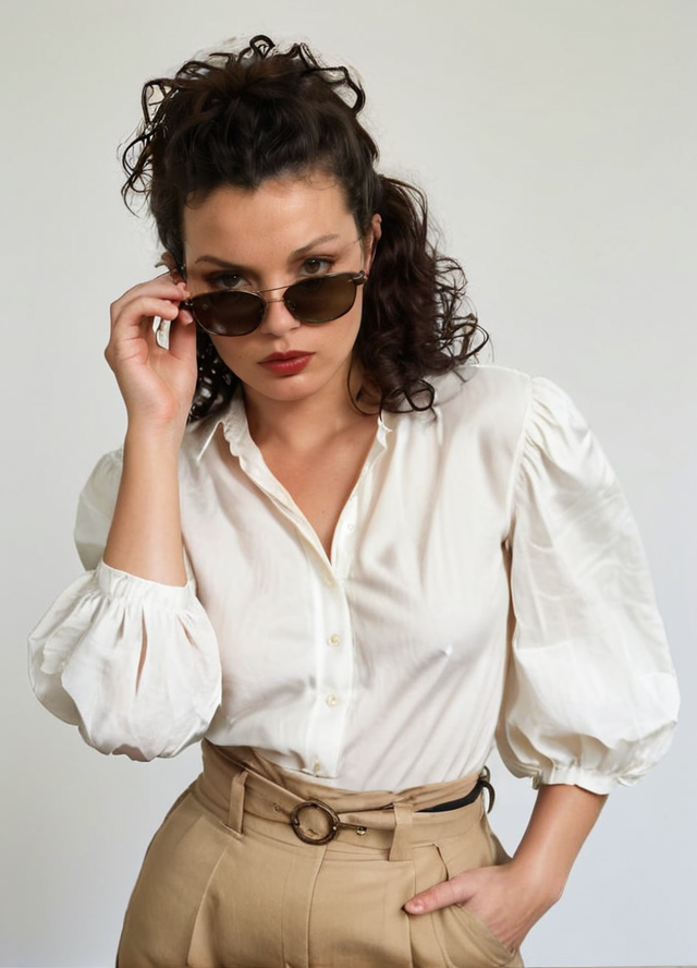 photo of a kate moss, head tilted to the side of an adult Light Skin women taken by edward weston, (((she is wearing a Puff-sleeve blouse and Paperbag waist pants)), looking at viewer with Disgusted:1.2, pulling down sunglasses, posed with hands on glasses, jet black curly hair , full lips, Kodak Motion Picture Film Style ,  <lora:add-detail-xl:1> <lora:style_lora_dadaptadam_realis:.45> <lora:PerfectEyesXL:.25> , solo,1girl, perfect human anatomy, perfecteyes, black eyes, <lora:Kodak Motion Picture Film Style v5_2:.9> slim thick thighs <lora:TeethXL:.1> ((medium perky breasts covered)) ziprealism <lora:SexyConiAI:.15> <lora:polyhedron_all_sdxl:0.2>, <lora:last:.15> <lora:NaturalBodyV2.0-C:0.2>,    <lora:pulling_sunglasses_down_XL:1>