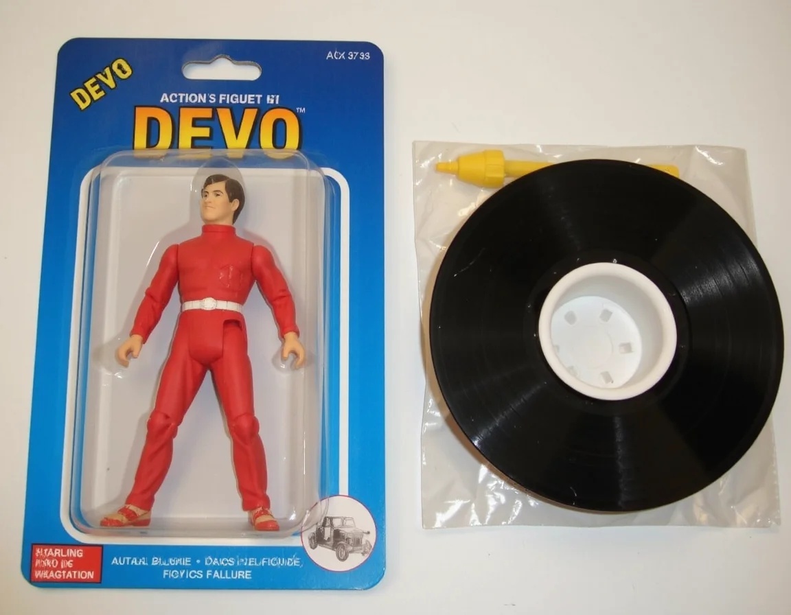 <lora:Knockoff_Toy_Twister_FLUX:1> Action Figure: The image is a photograph of a packaged action figure of (DEVO).