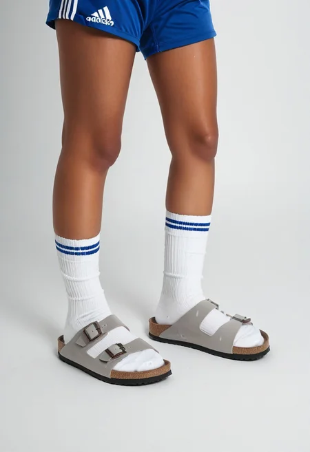 photorealistic, masterpiece, best quality.
1girl, solo, simple_background, white_background, standing.
calves, thighs, adidas_shorts, lower_body, slippers, footwear_focus, scksnsndls, birksonsocks.