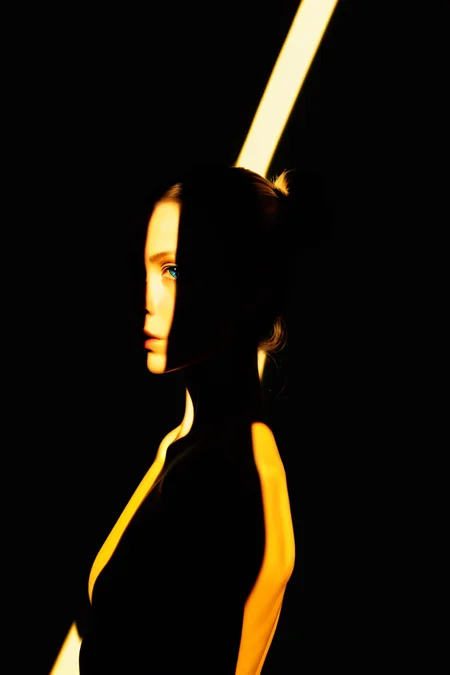 1girl,spotlight,silhouette,looking at viewer,cowboy shot,hair bun,gallus,simple background,yellow background,dark theme,<lora:spotlight:0.6>,