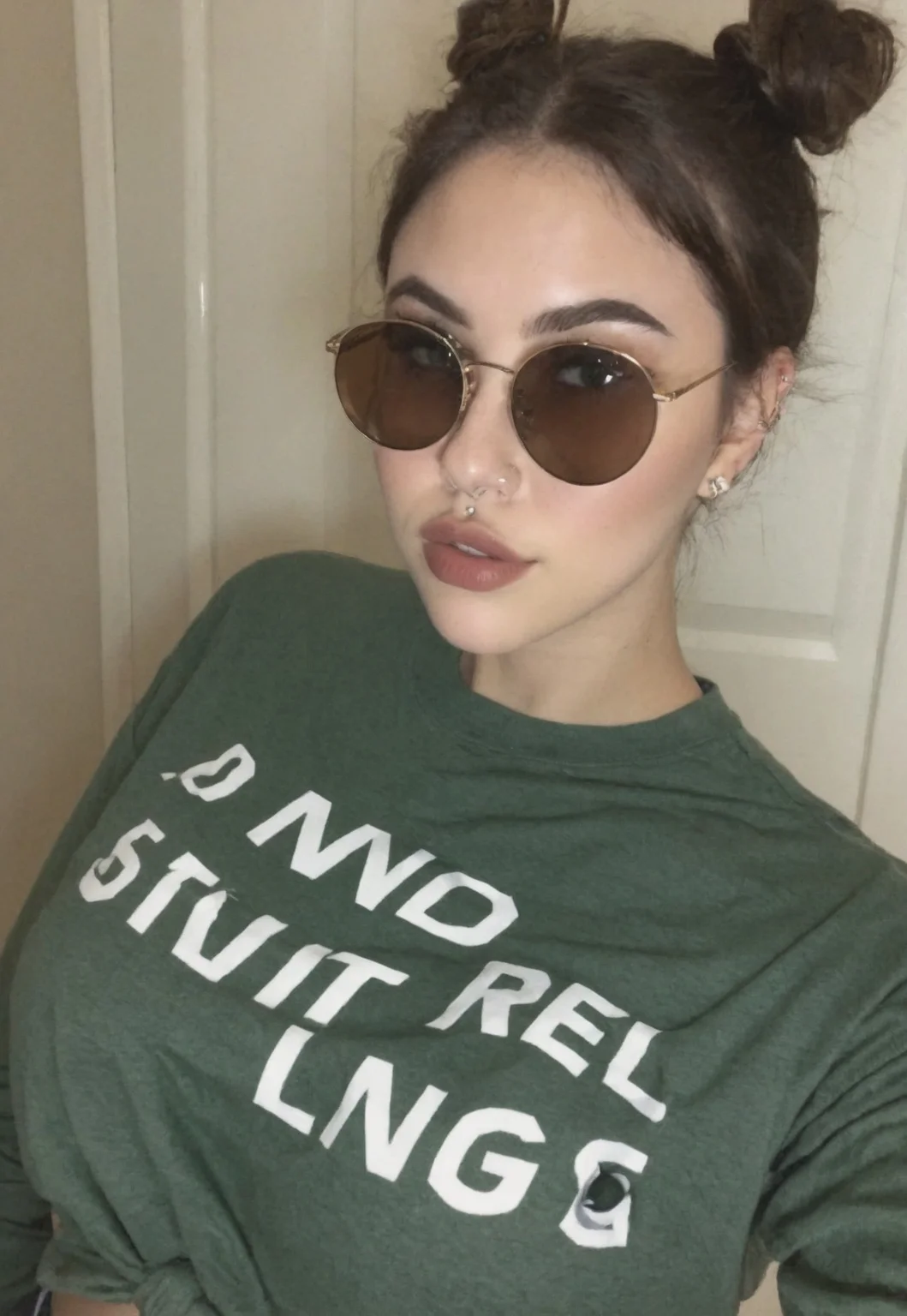 film grain, instagram model, 1girl, ear_blush, nose_blush, blush, round_sunglasses, eyewear, barbell_piercing, short_hair, twinbuns, tied_hair, (dark-brown_hair), green_eyes, full_lips, lips, parted_lips, untucked clothes, oversized_clothes, (black-cropped shirt), long_sleeves, portrait, sexy, amateur photo, dynamic, masterpiece, best quality, (ultra-detailed), absurdres, very aesthetic, newest, 2025, latest, amtr2, photo taken
