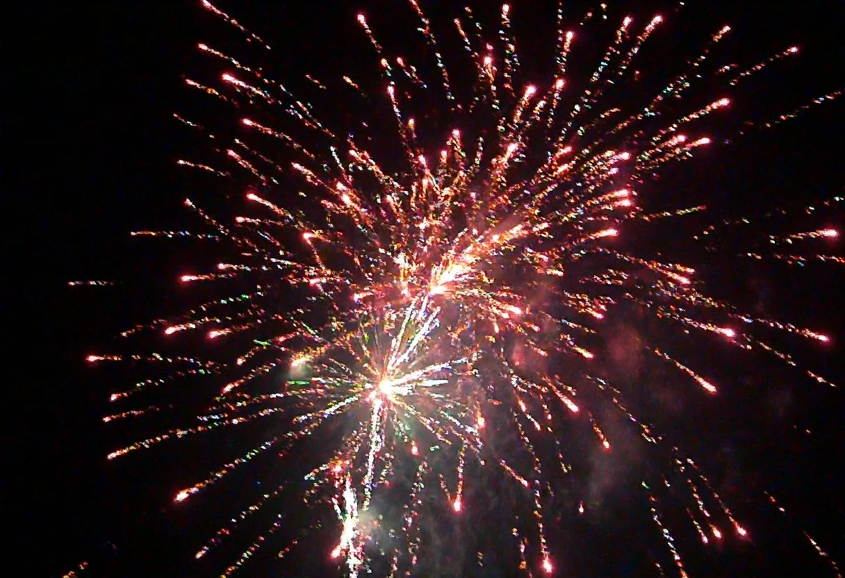 m8vic2, Bright colorful fireworks display, multiple bursts with red, orange, white, and green sparks, night sky background, dense smoke trails, vivid streaks of light radiating outward, outdoor setting, dark atmosphere, overexposed light from fireworks bursts, no visible text or signage, dynamic view upward.,