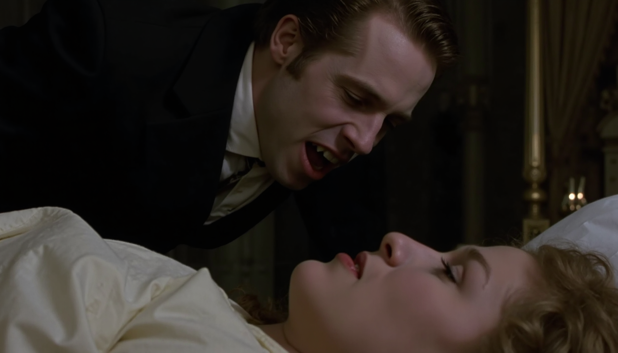 cinematic medium shot of a vampire man in a dark suit with very pale skin and open mouth showing fangs looming over a young woman sleeping on a bed. The woman has her mouth closed and a light tan, victorian bedroom, at night dark in soft light, analogue film, IMAX, photorealistic, very detailed <lora:iwtv_flux_1_0:1>