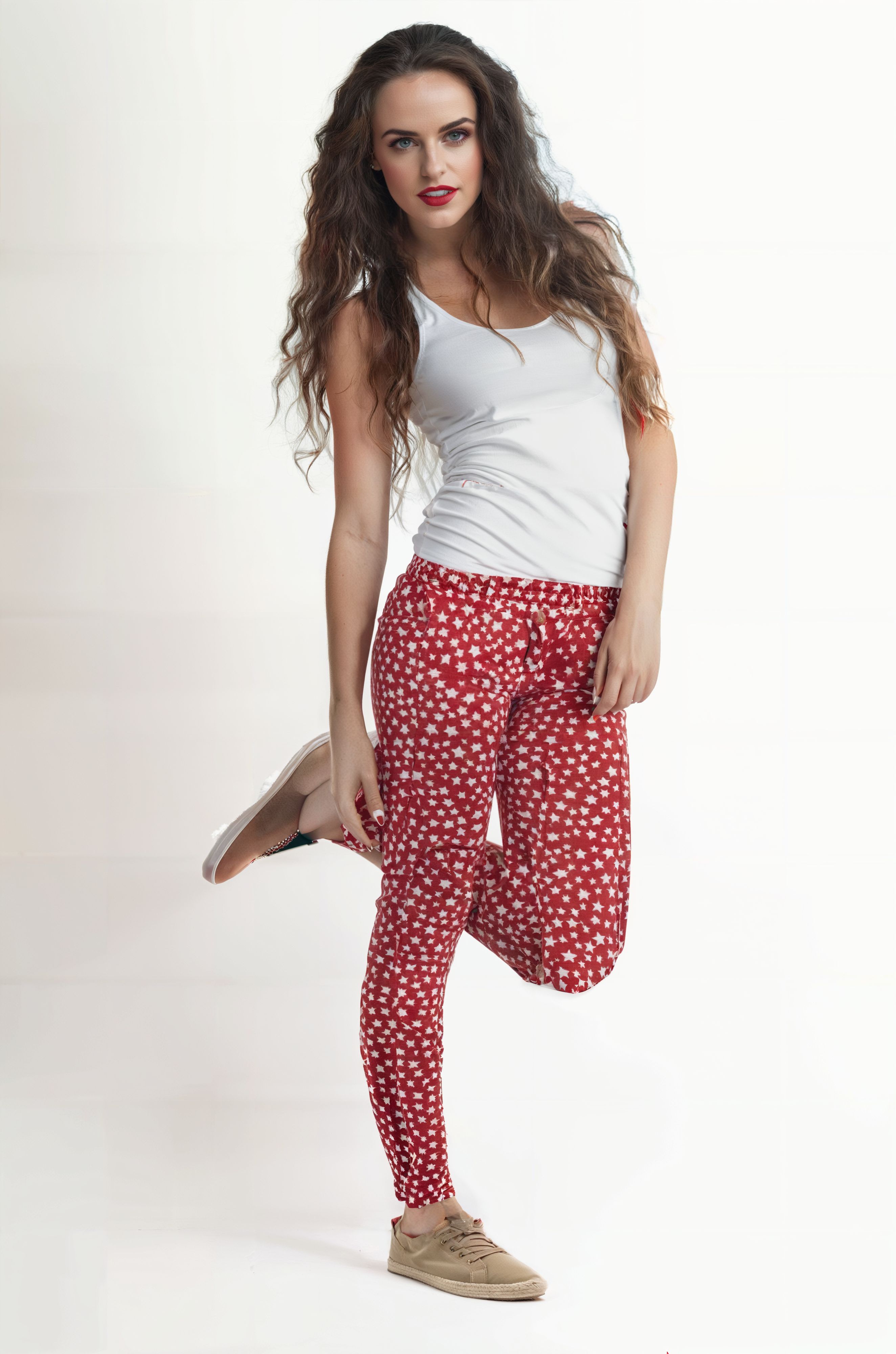 a woman in red and white pants and a white tank top posing for a picture with her legs crossed,raw photo,8k uhd,dslr,soft lighting,high quality,film grain,Hyperrealismus hyperrealistic,detailed face,realistic eyes,European face,