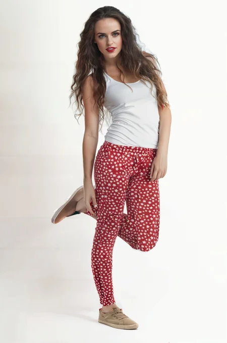 a woman in red and white pants and a white tank top posing for a picture with her legs crossed,raw photo,8k uhd,dslr,soft lighting,high quality,film grain,Hyperrealismus hyperrealistic,detailed face,realistic eyes,European face,