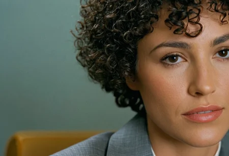 Film Still, close-up shot, 35 years old woman wearing gray suit, short curly hair, soft natural lighting, Shot on 70MM film, kodak vision 3 500t Film, ISO 100, f/4, 58mm focal length, movie still, panavision 70, Cinematic, cinematic color grading, (sharp details, high quality, 8k, intricate details, highly-detailed, masterpiece, award-winning, professional, highly detailed)