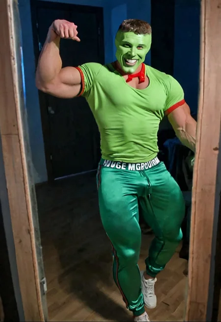 Extremely muscular strong handsome young grinning lustful man with a green head wearing tight joggers looking at himself in through a mirror in his flat at night, big bulge, large biceps, wide shoulders, muscular legs, the_mask