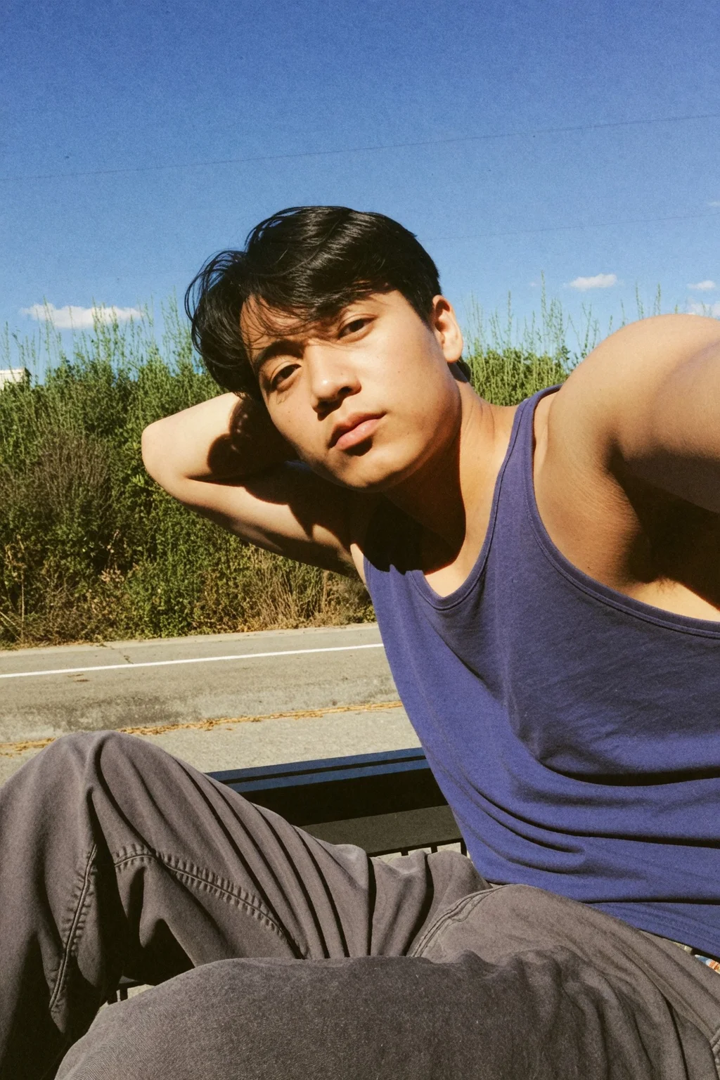 A handsome young korean man wearing no shirt and baggy trousers sitting. (Muscular:1.1), hand on head, posing, selfie,