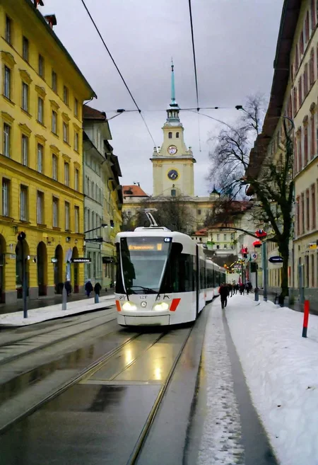 Bern downtown in winter, snowy, cloudy, people, modern tram, raw style