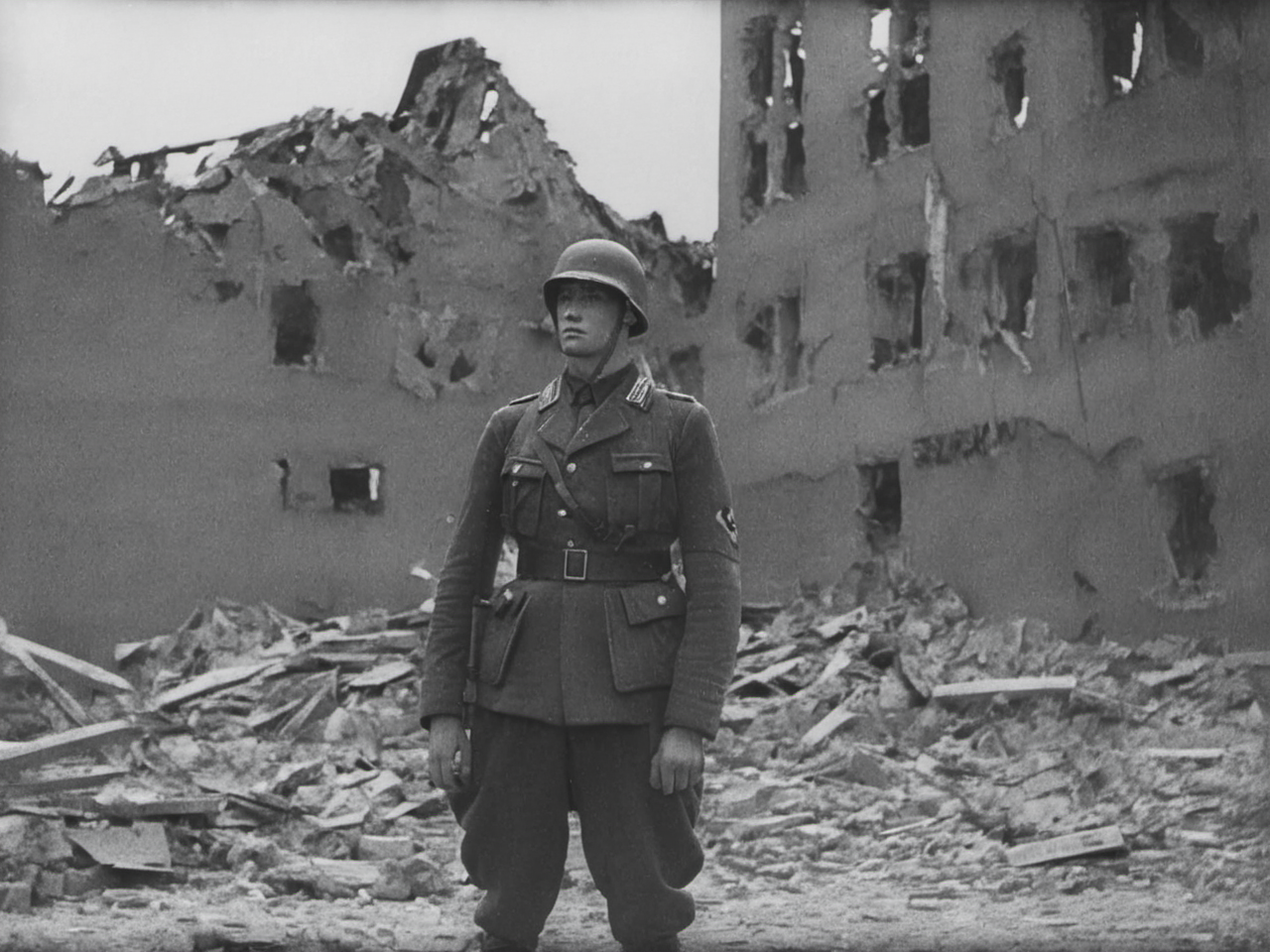 leni reifenstahl style photo of a german wwii soldier, standing in front of a destroyed building <lora:XL_Leni_Riefenstahl_Style_-_Triumph_of_the_LoRA_XL:1>