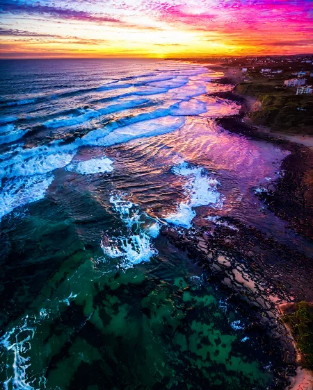vertical perspective aerial photography, natural, water, coast, sunset, ocean, beach, waves, <lora:sky:0.8>
