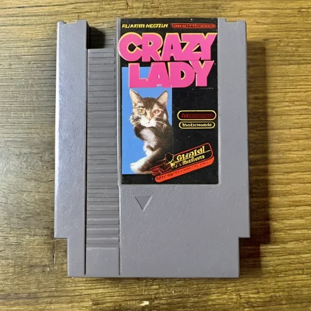 nes videogame cartridge, Crazy Cat Lady, english text, no humans, solo, parody <lora:nes:1>