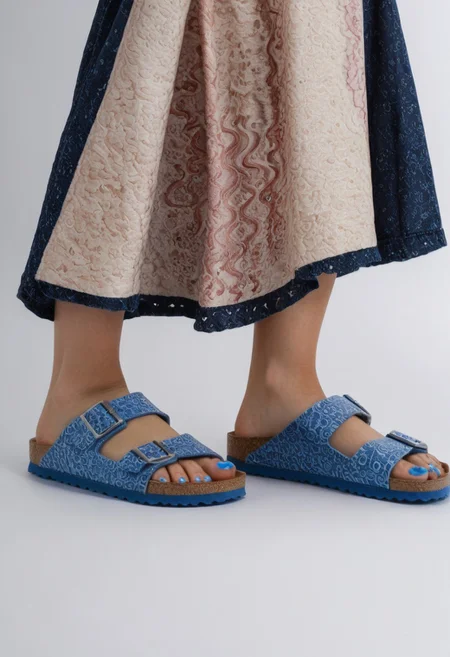 1girl, solo, simple_background, white_background, birksonfeet, blue_toenail_polish, close-up, lower_body, footwear_focus, patterned, long_skirt