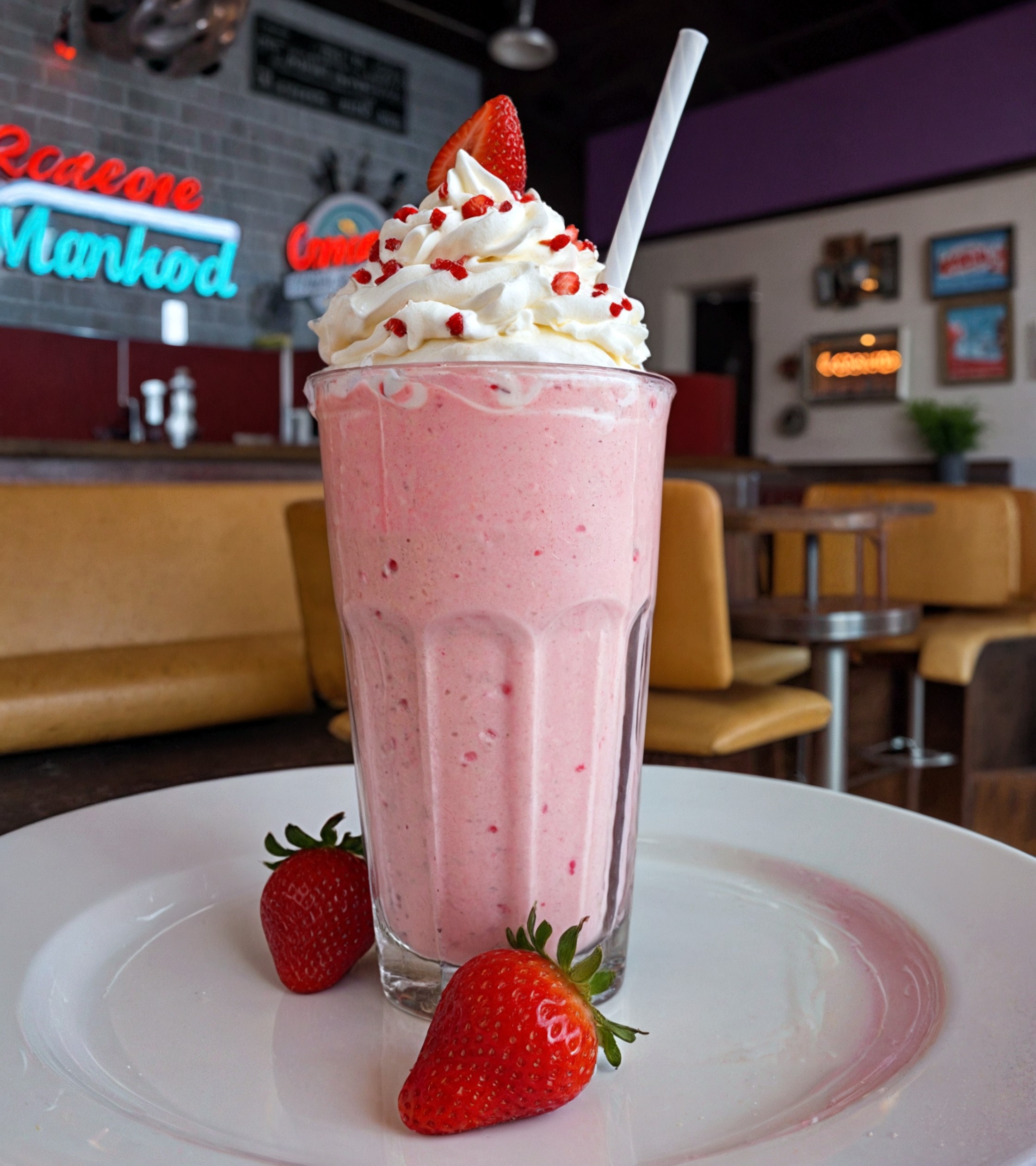 cinematic photo This creative and delicious strawberry falooda milkshake is a feast for the eyes and taste buds, with layers of creamy milk,  all topped with a swirl of whipped cream and a sprinkle of dried strawberry , on a saucer. in a cute American diner,  Choose from a range of render styles, from realistic to abstract, to bring your milkshake to life.  Movie Still, Film Still, Cinematic, Cinematic Shot, Cinematic Lighting, cinematic, colorful background, 8k, dramatic lighting, high detail, highly detailed, hyper realistic, intricate, intricate sharp details, octane render, smooth, studio lighting, ., cinematic  photorealistic, 8k uhd natural lighting, raw, rich, intricate details, key visual, atmospheric lighting, 35mm photograph, film, bokeh, professional, 4k, highly detailed . 35mm photograph, film, bokeh, professional, 4k, highly detailed