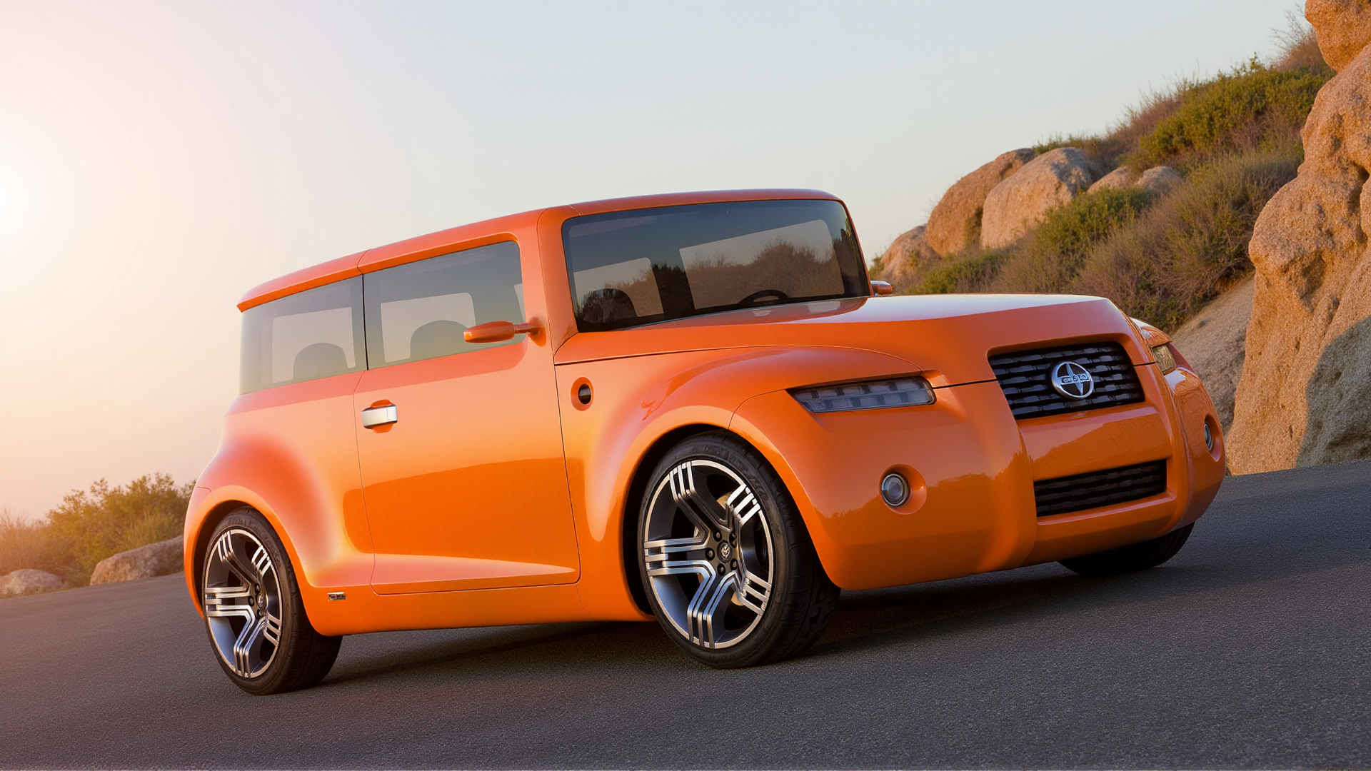 A photorealistic depiction of the Scion Hako Coupe Concept parked on a winding mountain road at sunrise. The carâs bold, boxy proportions and retro-modern design are highlighted by the bright orange paint, glowing warmly in the golden sunlight. The wraparound panoramic glass reflects the clear blue sky and the first rays of morning light. Its wide grille, narrow horizontal LED headlights with grid-like patterns, and circular fog lights stand out crisply against the natural backdrop. Polished multi-spoke alloy wheels and sculpted wheel arches are framed by the curve of the road, with rocky cliffs and sparse greenery adding depth to the serene scene
 <lora:ral-hkcpcncpt_000004000:1>