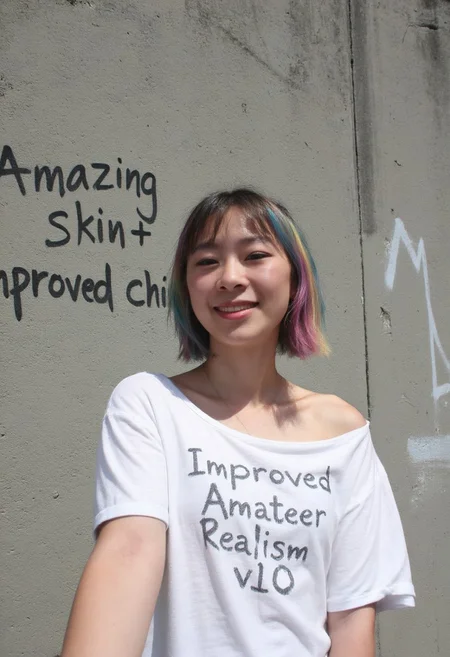 early 2010s snapshot photo captured with a phone and uploaded to facebook, A selfie of a young japanese woman standing in front of a concrete wall with graffiti on it that reads "amazing skin + improved chins". She is wearing a slightly off-shoulder baggy white t-shirt with the text "Improved Amateur Realism v10" written on it. She has short hair styled in a bobcut and dyed in multiple rainbow-like colors. She is happy and smiling. Shot during the day with natural lighting and sunshine.