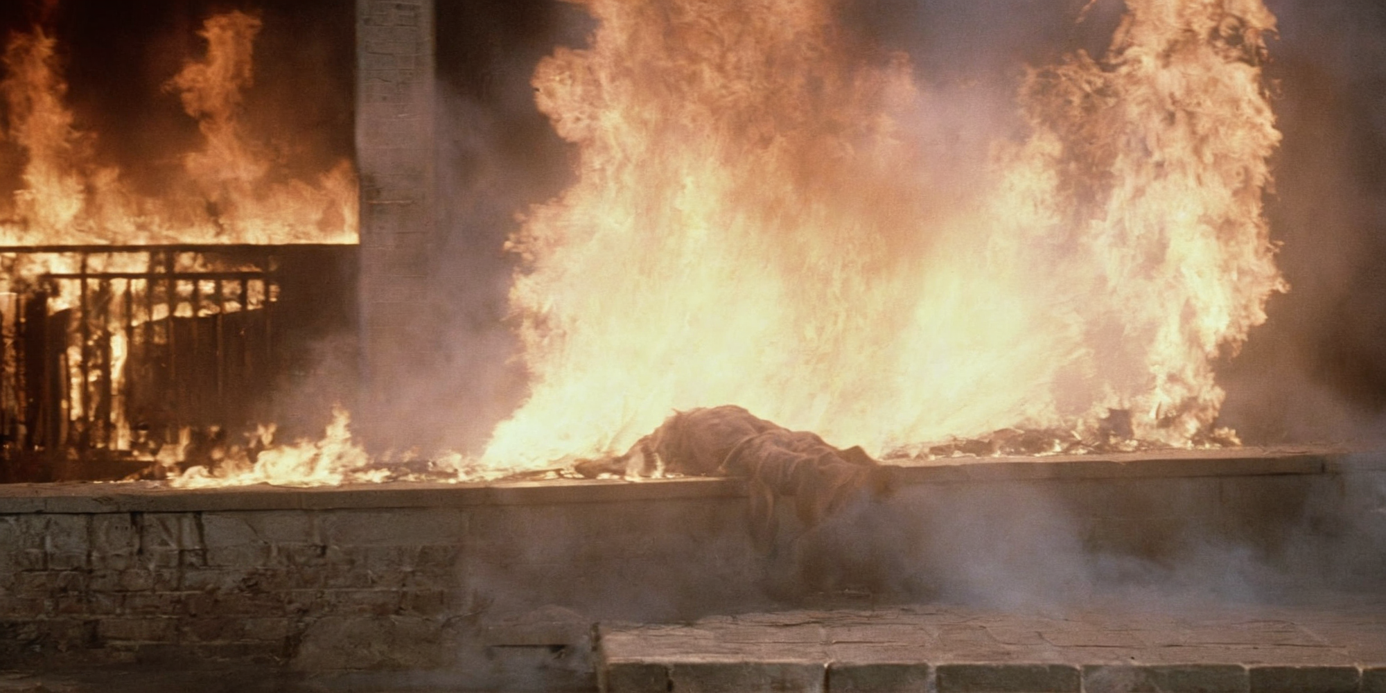 Horror-themed,  <lora:Fright Night 1985 Film Style:1>
Cinematic Medium Shot Film Footage captured by Panavision Cameras and Lenses a huge fireball is hitting a vampire creature person, laying on a wall with a huge fire spewing on, Fright Night 1985 Film Style, Eerie, unsettling, dark, spooky, suspenseful, grim, highly detailed