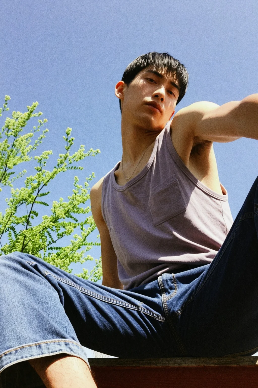 A handsome young korean man wearing no shirt and baggy trousers sitting. (Muscular:1.1), hand on head, posing, selfie,
