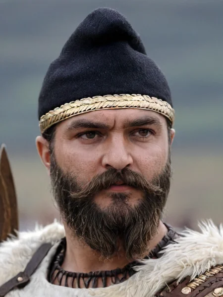 dacian warrior, phrygian cap, solo, 1boy, hat, male focus, blurry, facial hair, beard, mustache, photo background, masterpiece photography,8k <lora:dacii:1>