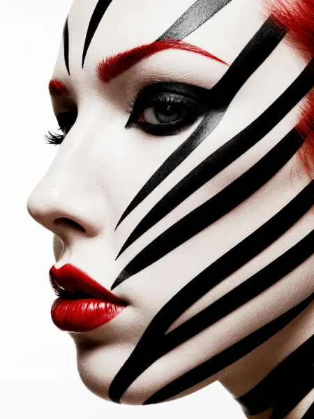 A striking close-up profile of a woman’s face adorned with bold, black stripes that wrap around the contours of her face, creating a hypnotic, zebra-like pattern against her smooth, pale skin. Her eyelids are covered in deep, matte black makeup that accentuates her long eyelashes, while her lips stand out in a glossy, vibrant red, offering a sharp contrast to the monochrome stripes. The image is minimalist yet visually intense, with the pattern seamlessly flowing across her features, evoking a sense of modern art and surreal beauty.
RAW photo, masterpiece, photorealistic, 8k, best quality, stunning eyes, skin detail, skin pores, blemishes