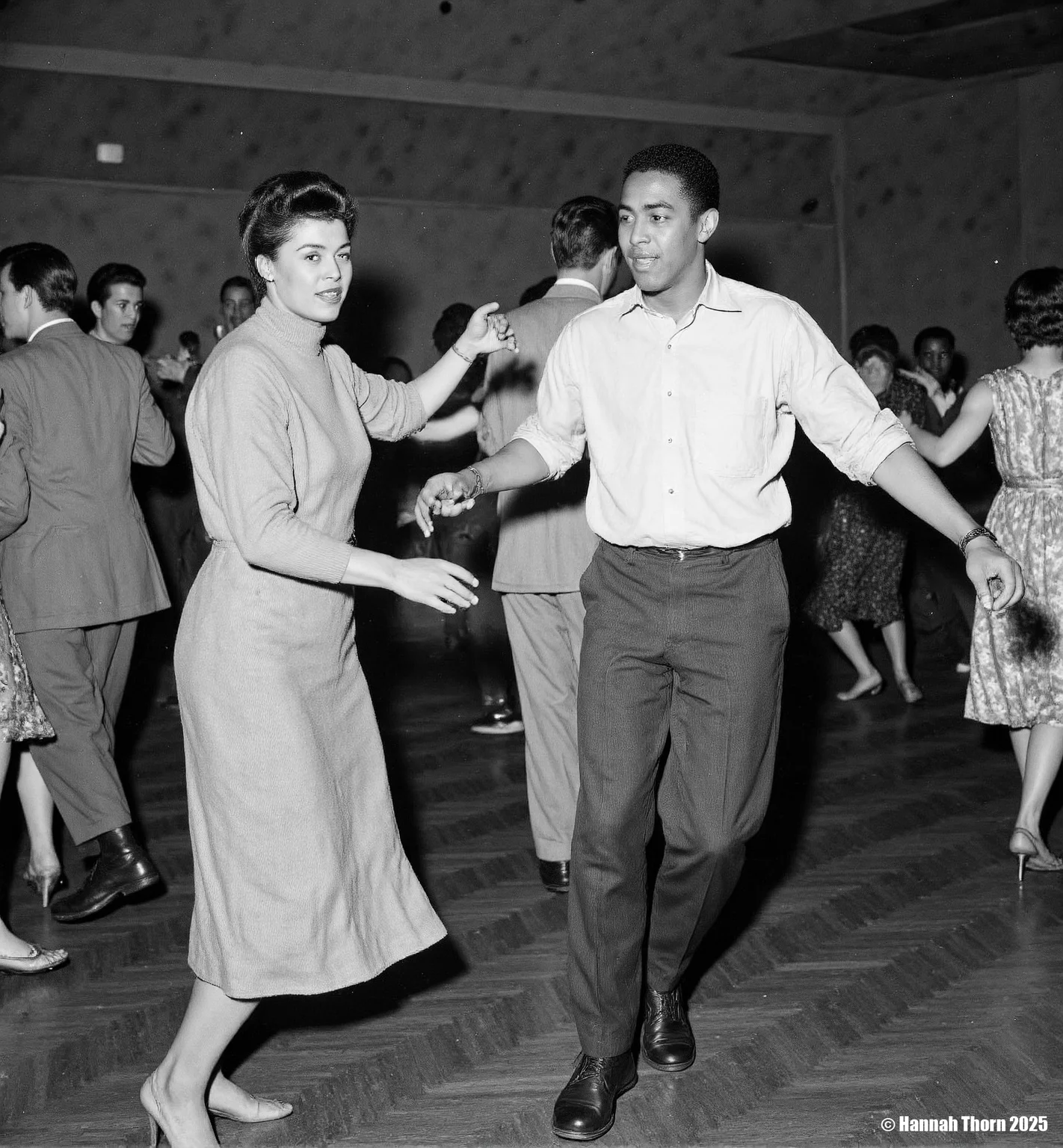 The picture is a black and white photograph depicting a lively dance scene, likely at a social event or club in the mid-20th century. The focus is on a young Afro-American couple dancing. The woman, wearing a simple, elegant sweater and a knee-length skirt, is moving with grace. Her partner is stylishly dressed in a light-colored shirt and dark trousers. He appears to be leading the dance. In the background, other couples and people are visible, enjoying the music. A saxophone player is noticeable amidst the dancers, indicating a jazz or swing atmosphere. The background is blurred, drawing attention to the main dancing couple in the foreground. The overall style suggests candid photography, capturing the spontaneous energy of the moment. The photographic style is reminiscent of photojournalism or street photography from the mid-20th century. The use of black and white enhances the contrast and mood, creating a timeless quality. The slightly grainy texture and focus on capturing movement in a realistic manner further contributes to the authenticity of the scene. The shallow depth of field keeps the focus sharply on the central dancing couple while maintaining enough context through the slightly blurred background. The composition, with the central couple framed in the dance floor, guides the viewer's attention effectively. <lora:_Flux\Vintage_Jazz-Club.safetensors:1.0:1.0>