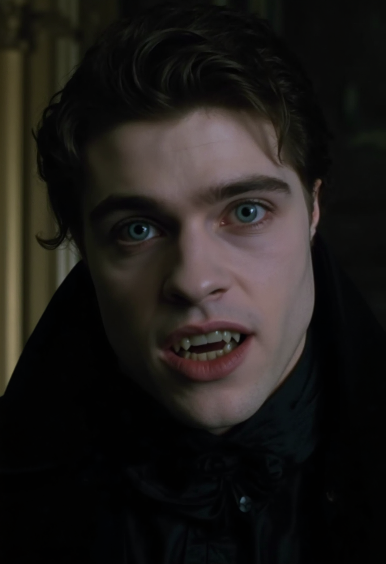 cinematic ultra close-up face shot of a young aristocratic vampire man looking directly at the camery with a crazy, wide-eyed expression, lips slightly parted showing fangs. Extremely pale skin standing in sharp contrast to dark hair and a black silk shirt, prominent cheek bones, bright detailed blue eyes, dark make-up around eyes dark victorian room in the background, at night in soft light, analogue film, IMAX, photorealistic, very detailed <lora:iwtv_flux_1_0:1>