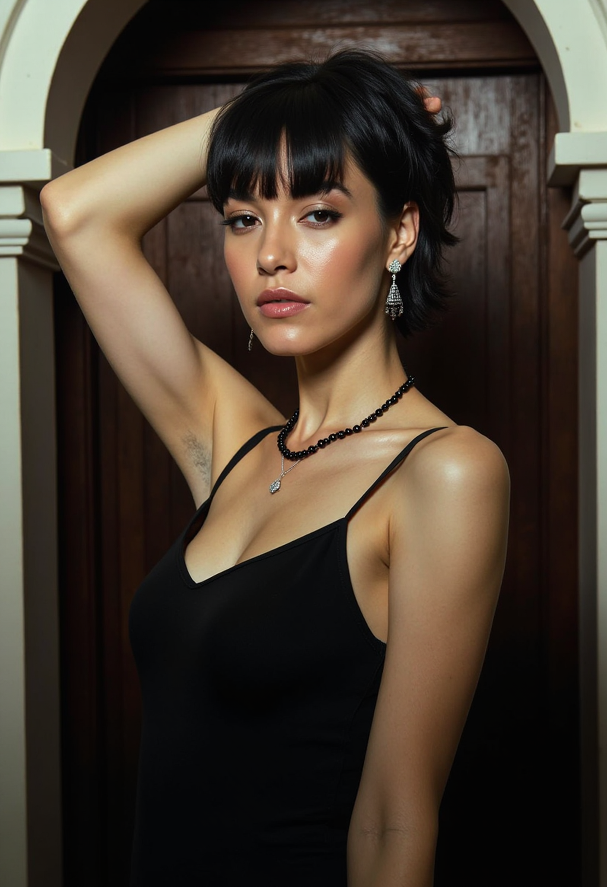 realistic photo of a thin woman with short black hair, She is wearing a sleeveless black dress with one of her arms up showing her armpit. She is standing in the entrance to a Limbo and is dressed very formally with small diamond earrings and a small black pearl necklace, armpitstubble