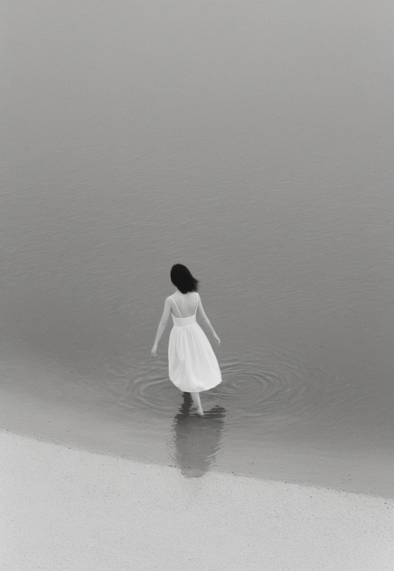 Girl Walking on the water wearing white dress, Completely White background, abstract, surreal, Soft diffused lighting, grayscale, Monochromatic, Black and White, Muted Tones, Minimalist, Ethereal, Leica MP, Leica Noctilux 50mm f0.95  Lens, Kodak Tri-X 400 Film, 35mm Film, Film Grain, Film halation